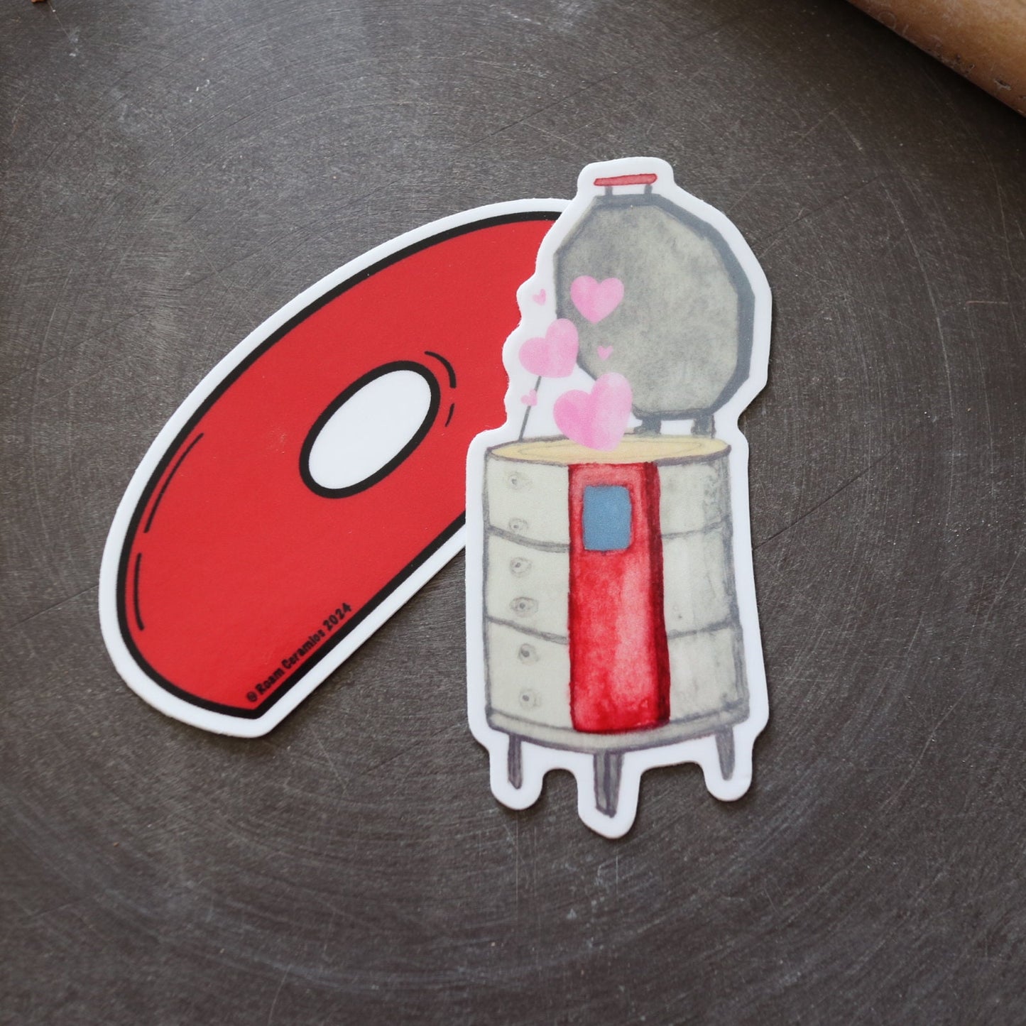 a kiln sticker and a red rubber rib sticker underneath